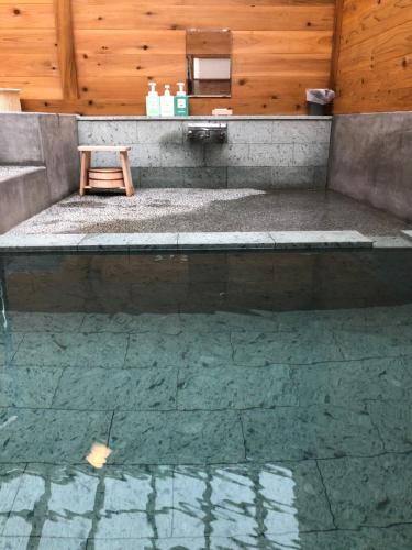 a bathroom with a bench and a wooden wall at yuzaka - natural & sustainable inn - in Kazuno