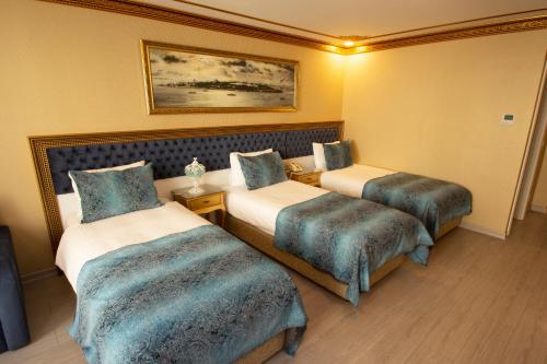 a hotel room with two beds with blue covers at Empire Suite Hotel in Istanbul