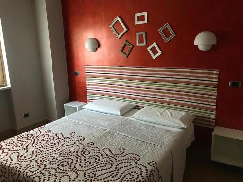 ein Schlafzimmer mit einem Bett mit einer roten Wand in der Unterkunft La casetta di Simone in Cassino