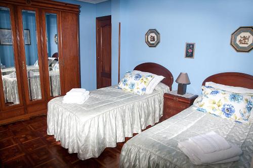 two beds in a room with blue walls at DUPLEX LLANES CENTRO-PLAYA, tranquilo y con garaje in Llanes