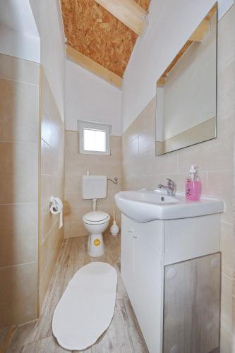 a white bathroom with a toilet and a sink at House Old Fisherman in Tkon