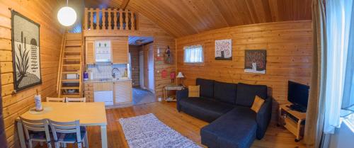a living room with a couch and a table at Holiday Village Kuukiuru in Vuostimo