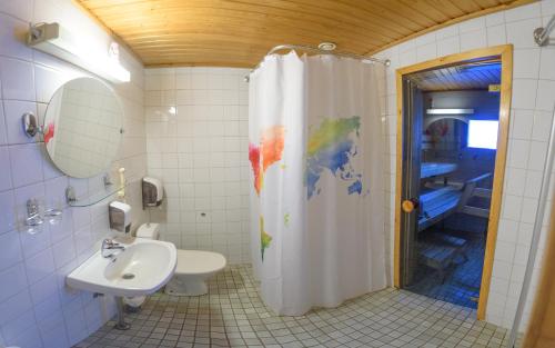 a bathroom with a shower and a toilet and a sink at Holiday Village Kuukiuru in Vuostimo