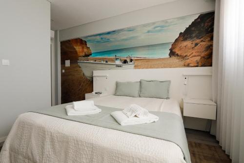 a bedroom with a bed with a painting on the wall at Golden Beach Guest House & Rooftop Bar in Faro