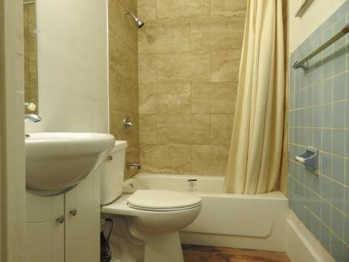 ein Badezimmer mit einem WC, einem Waschbecken und einer Badewanne in der Unterkunft LAWRENCEBURG MOTEL in Greendale