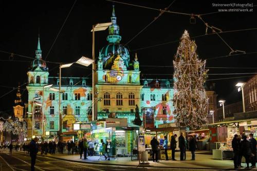 a large building with a christmas tree in front of it at Wohnung am Grazer Hauptplatz in Graz
