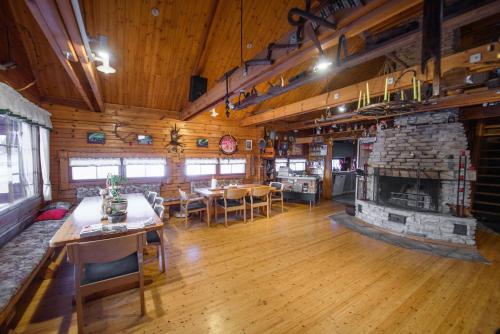 a large room with a stone fireplace in a log cabin at Holiday Village Kuukiuru in Vuostimo