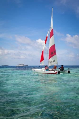 a small sail boat in the water on the ocean at Eriyadu Island Resort in Reethi Rah