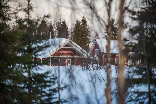 a large red house with snow on the roof at Holiday Village Kuukiuru in Vuostimo