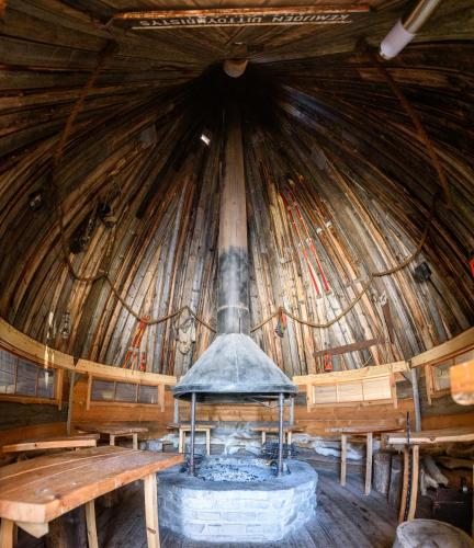 a large wooden hut with a stove in the middle at Holiday Village Kuukiuru in Vuostimo