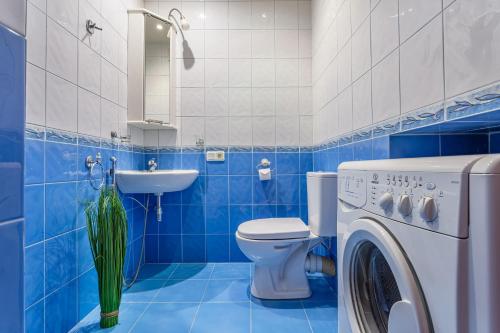 Baño de azulejos azules con aseo y lavamanos en Peter the Great Apartment near Hermitage with sauna, en San Petersburgo