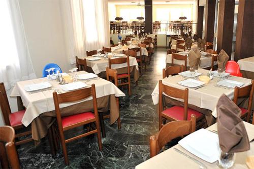 a dining room with tables and chairs with white tablecloths at Hotel Aquarius in Cattolica