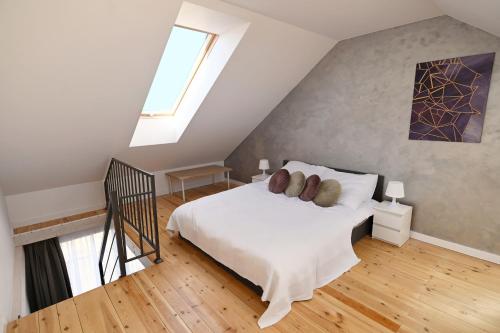 a bedroom with a white bed in a attic at Apartament Nadmorskie Wzgórze in Mechelinki