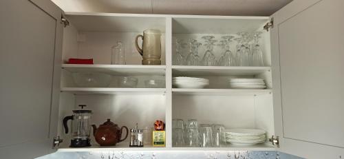 a kitchen cabinet filled with glasses and dishes at Seaside cottage Rebase Kuur in Keibu