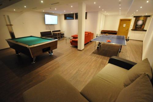 a living room with a pool table and a couch at Haus Passler in Sankt Jakob in Defereggen