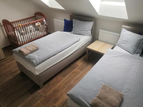 Un dormitorio con 2 camas y un banco. en Penzion Na Farmě, en Karle