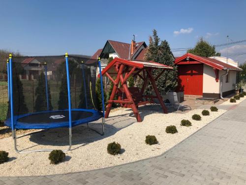 a playground with a swing set in a yard at Róma Apartmanház in Bogács