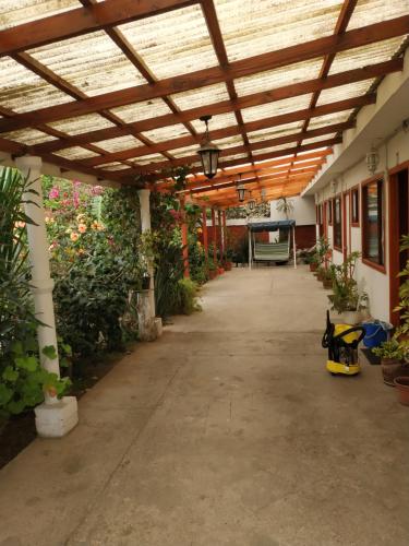 a covered walkway in a greenhouse with a wooden ceiling at Hotel Restaurante Aconcagua in La Ligua