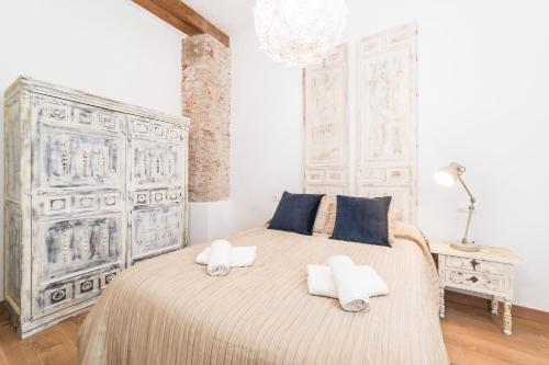 a bedroom with a large bed with two pillows at Suite Homes Uncibay Square in Málaga
