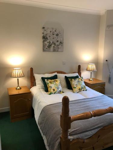 een slaapkamer met een bed met twee lampen op tafels bij Ros Dún House in Donegal