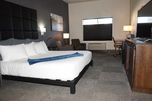 a hotel room with a bed and a flat screen tv at Wood River Inn & Suite in Hailey