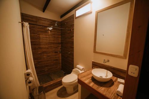 a bathroom with a toilet and a shower and a sink at El Sauce Resort in Sauce