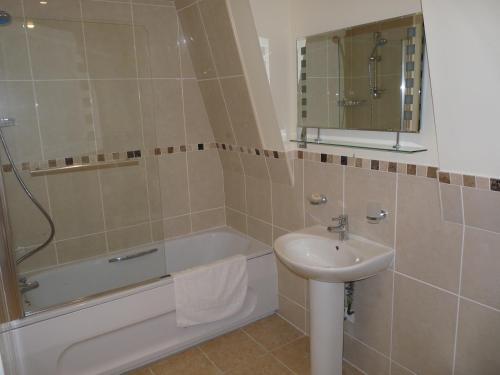 a bathroom with a tub and a sink and a shower at The Woodvale in Cowes