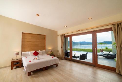 a bedroom with a large bed and a large window at El Sauce Resort in Sauce
