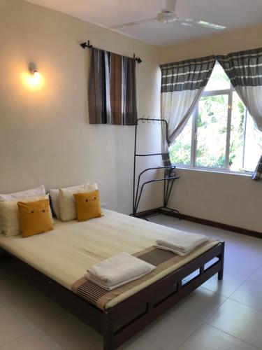 a large bed in a room with a window at Holiday Home Kotte in Nugegoda
