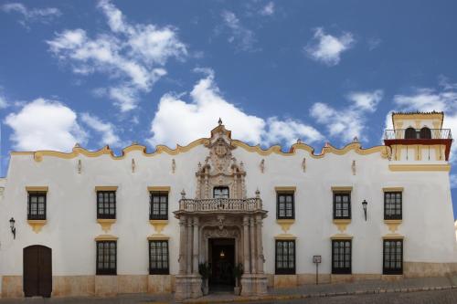 a large white building with a gate in front of it at Palacio Marques de la Gomera in Osuna