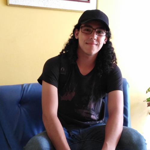 a man sitting on a couch wearing a hat and glasses at Hospedaje de Lidia in Lima