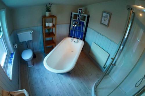 a bathroom with a shower and a tub and a toilet at Self contained stylish city home in Norwich
