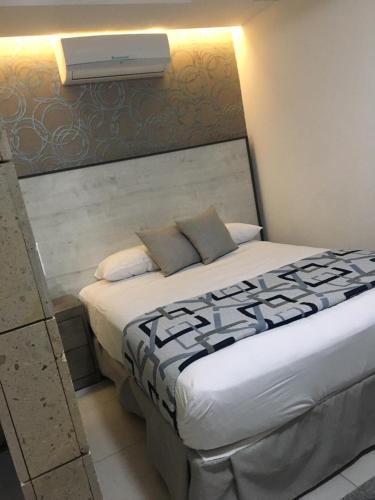 a bedroom with a large bed with a air conditioner on the wall at Suites André Confort Ejecutivo in Aguascalientes