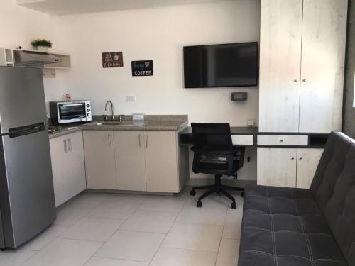 a kitchen with a desk and a chair in a room at Suites André Confort Ejecutivo in Aguascalientes