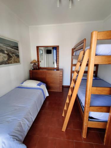 a bedroom with two bunk beds and a mirror at Apartamento Vargas in Monte Gordo