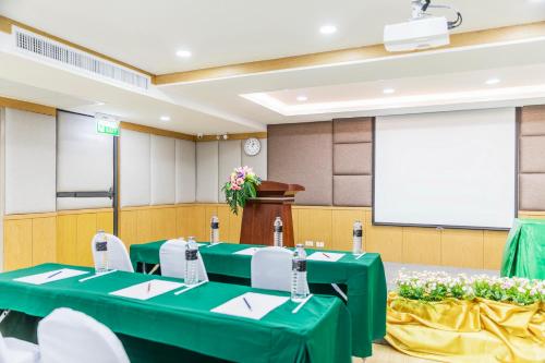 a conference room with green tables and a podium at Livotel Hotel Hua Mak Bangkok in Bangkok