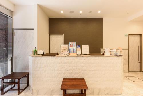 a restaurant with a counter with two stools at Shinbashi Urban Hotel in Tokyo