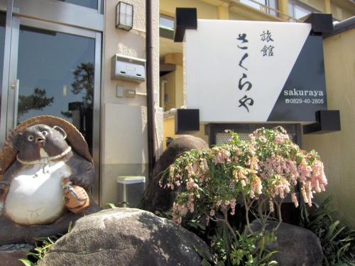 una statua di una scimmia di fronte a un edificio di Sakuraya a Miyajima