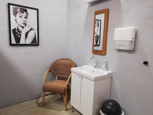 een witte badkamer met een wastafel en een stoel bij Eichenthal Ferienhaus in Geilenkirchen