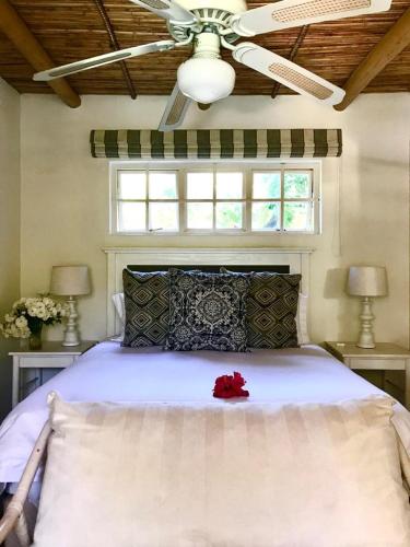 um quarto com uma cama com uma rosa vermelha sobre ela em Little Willow Brooke em Franschhoek