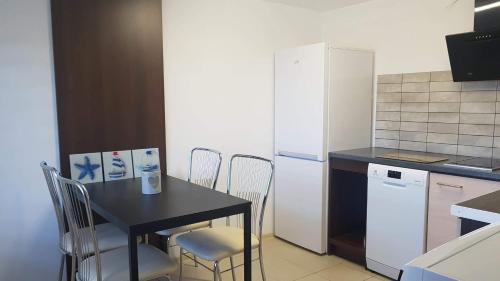 a kitchen with a black table and a white refrigerator at Willa Aster in Rewa