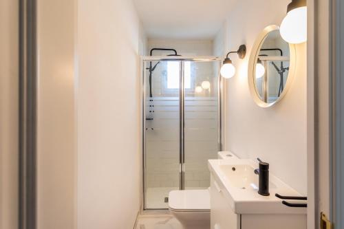 a white bathroom with a shower and a sink at Villa Orquidea in Fuengirola