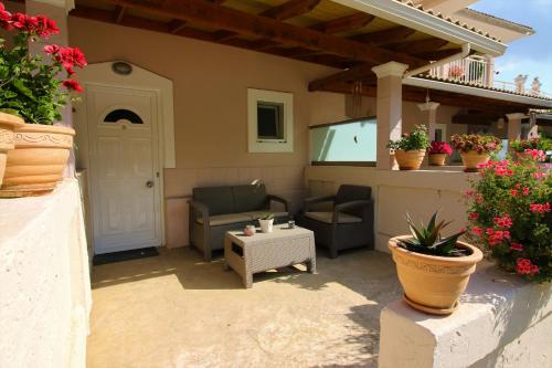 a patio with chairs and a table on a house at Santa Barbara Lakis Apartments in Perivolion