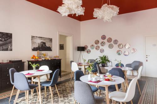 un ristorante con tavoli bianchi e sedie blu di B&B Palazzo Corselli a Bagheria