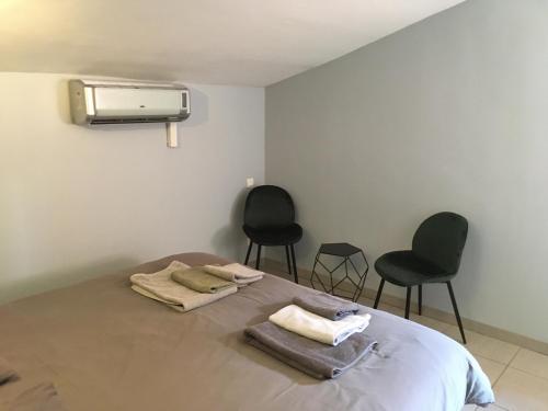 サント・マキシムにあるVilla Cote d'Asoetのベッドルーム1室(ベッド1台、椅子2脚、暖房付)