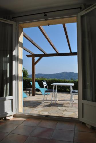 a sliding glass door leading to a patio with a table and chairs at Luciana in La Croix-Valmer
