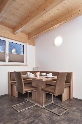a dining room with a wooden table and chairs at Apart Anemone in Niederthai