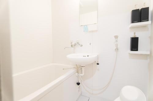 a white bathroom with a sink and a shower at Chiba LEO Yonju-Yonbankan #MLx in Funabashi