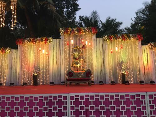 a stage with white curtains and a christmas tree at Toshali Sands Nature Escape Puri in Puri