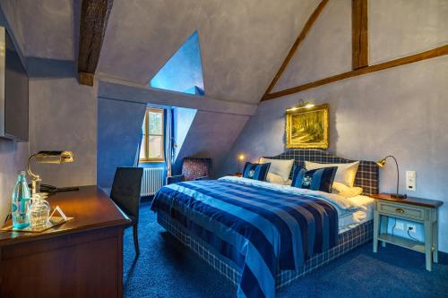a bedroom with a king sized bed and a desk at Schlosshotel Weyberhöfe in Hösbach